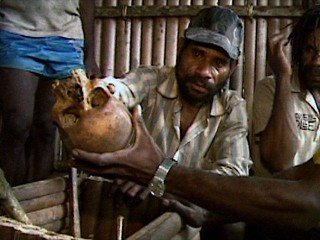 A Papuan shows the skull of his family member that was murdered by the Indonesian military during the massacre