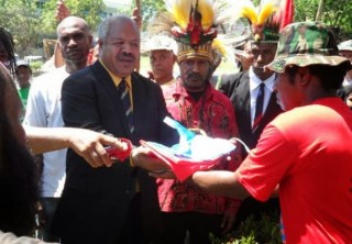 Powes Parkop receives the West Papuan flag alongside Benny Wenda shortly before raising it in in the capital of PNG