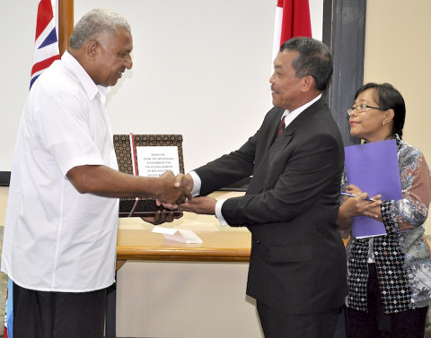 Fijian Prime Minister, Frank Bainimarama sickeningly shakes hands with Indonesian war criminal, Secretary of the Ministry of Co-ordination, Political, Legal and Security Affairs Lieutenant-General Langgeng Sulistiyono after accepting a bribe of $500,000.