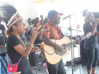 Sir George Telek performs on stage alongside West Papuan students