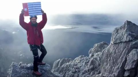 Christian  Welponer a world famous mountaineer flies the Morning Star flag on the peak of the highest mountain in West Papua in defiance of the Indonesian authorities.