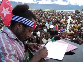 West Papuans signing documents at a rally