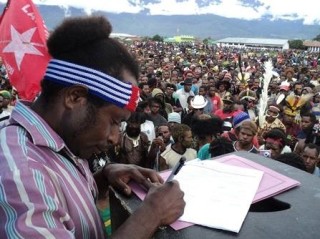 West Papuans signing documents at a rally